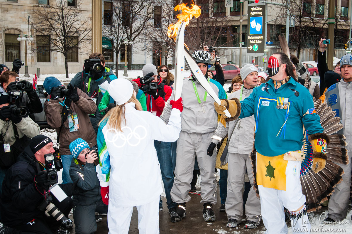 The exchange of the flame for the Olympic baton's next leg.